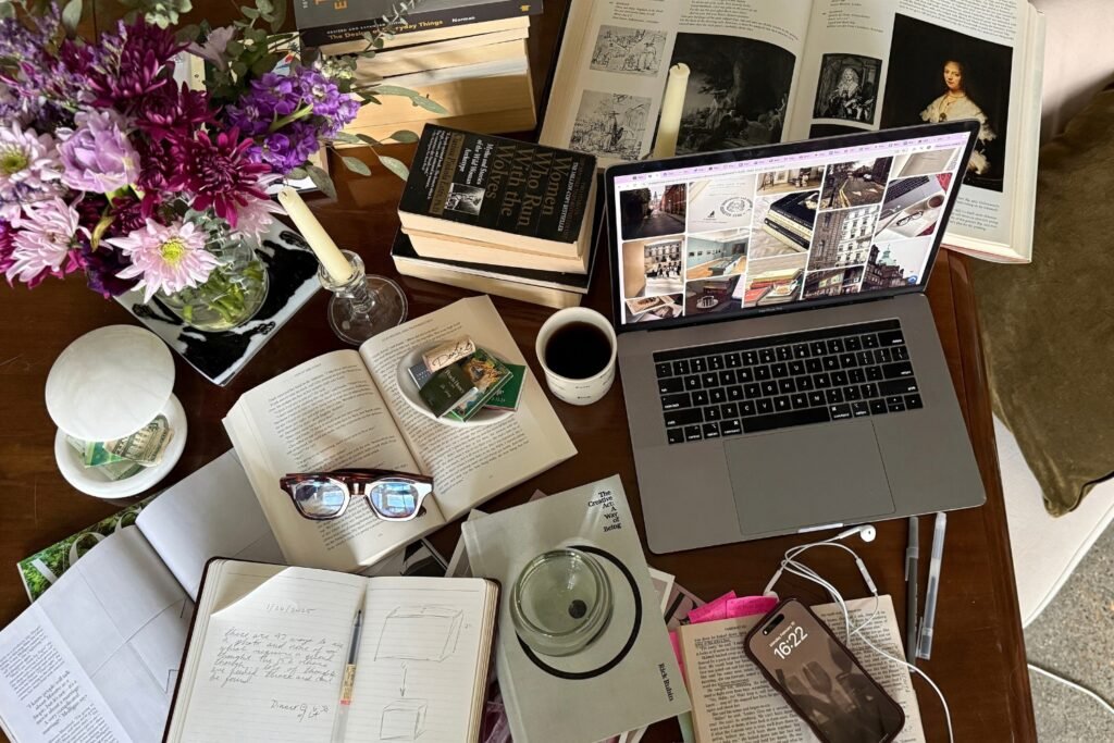 Creative workspace with laptop, notebook, and planning materials for weekly Pinterest content